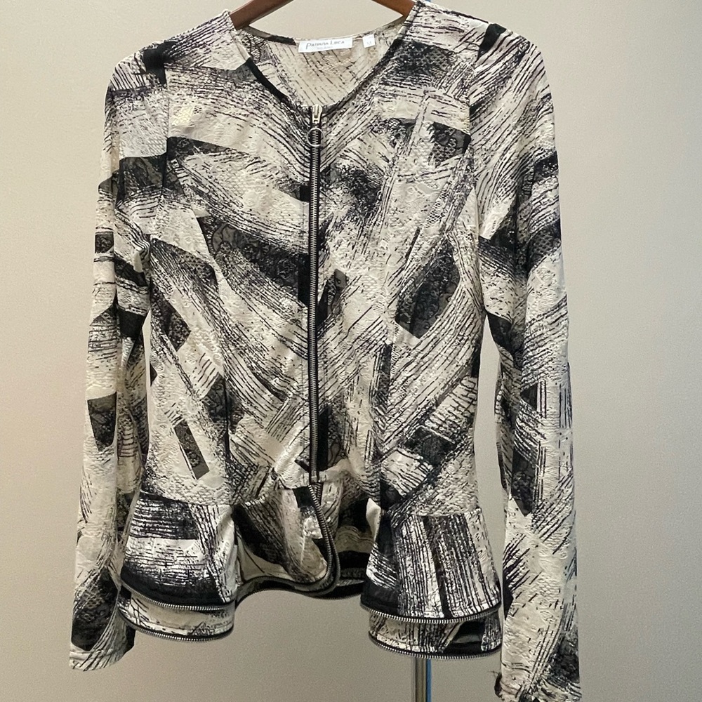 Black and cream netted top with peplum and zipper detail.